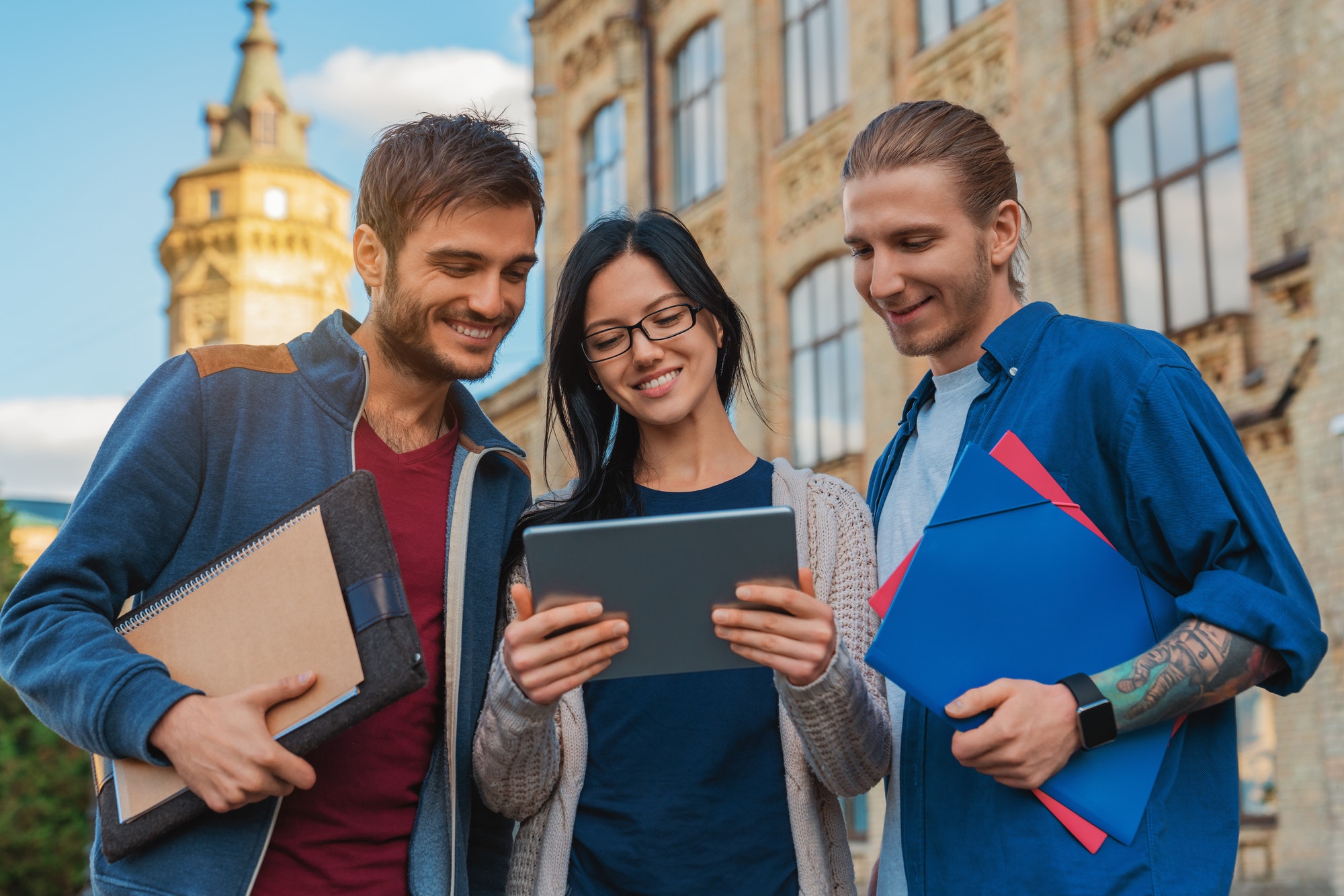 a-group-of-young-multi-ethnic-group-of-student-in-university-smiling-and-looking-at-the-tablet.jpg